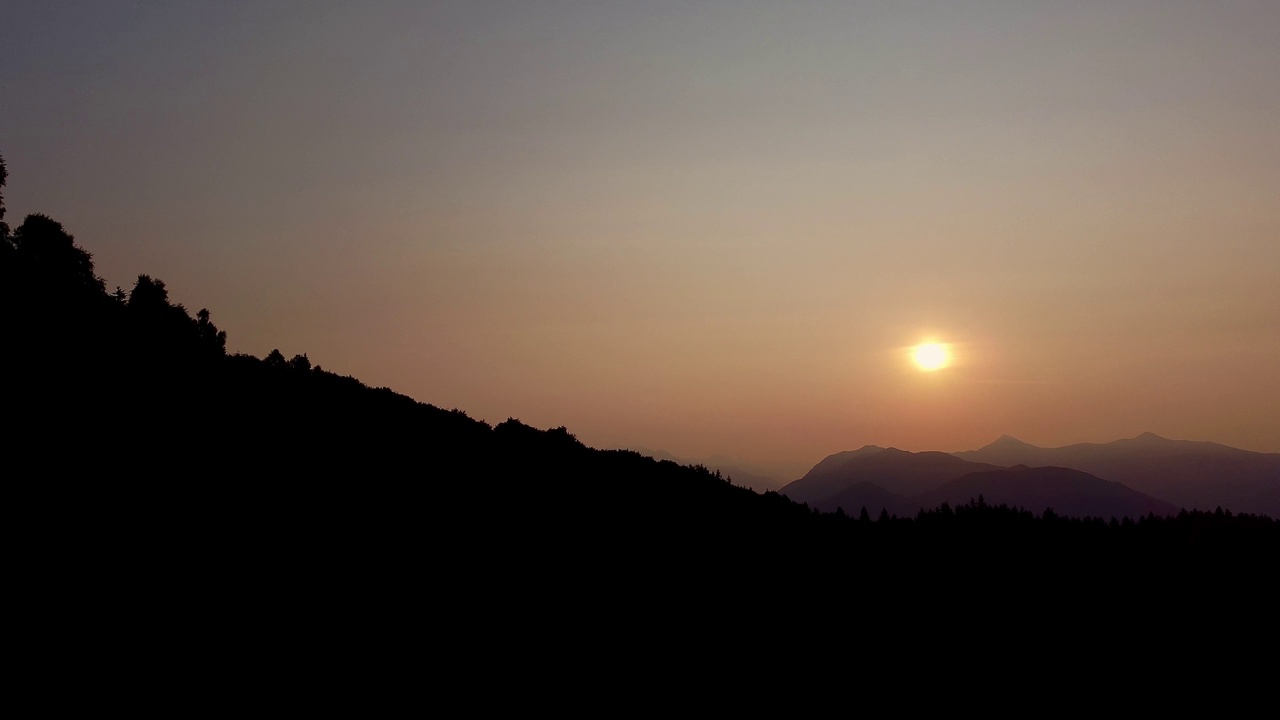 航拍的景观与河流之间的山丘对黄色夕阳天空视频素材