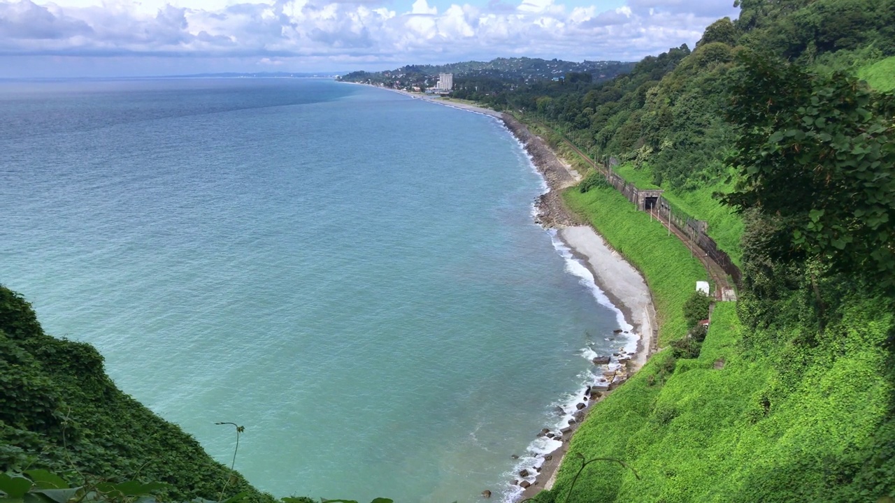 一列火车驶出隧道，沿着海岸行驶视频素材