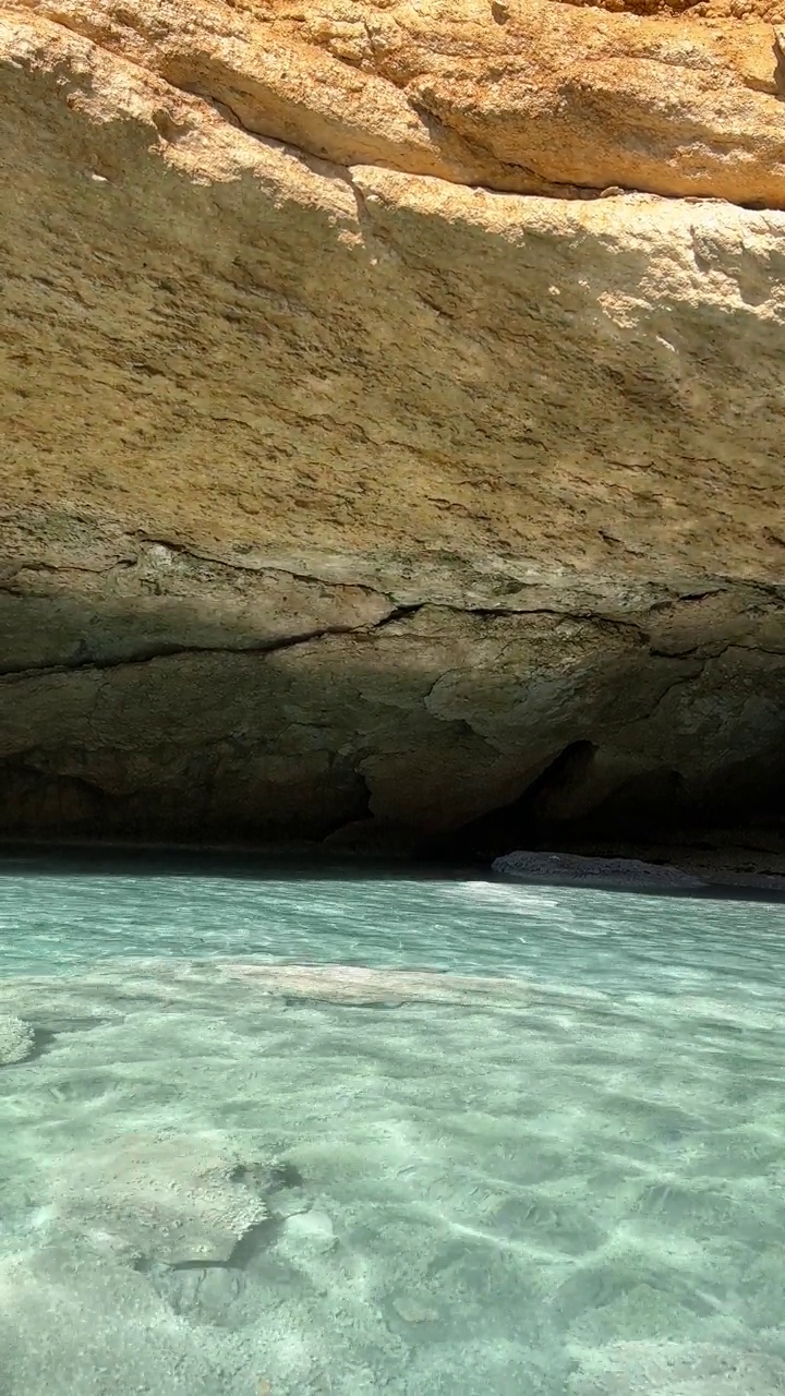 海洞石窟岩石清澈碧蓝，水面垂直视频。视频素材