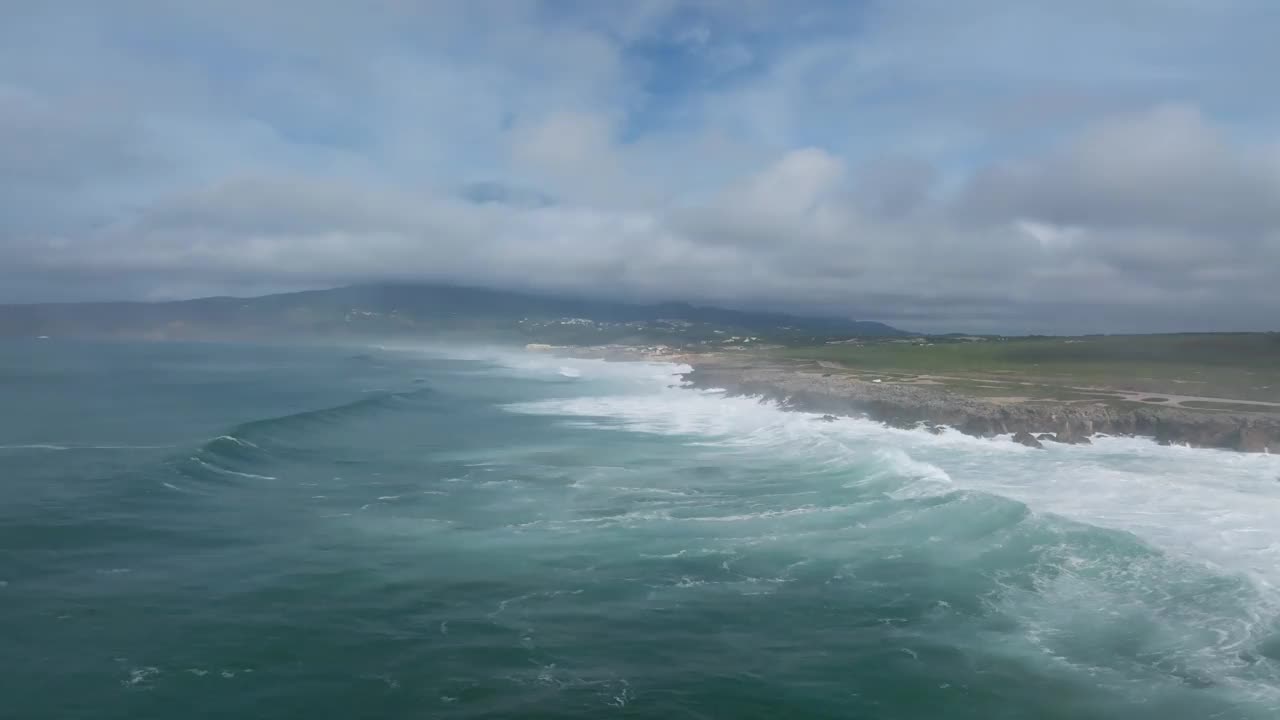 鸟瞰海浪和绿色海岸，金丘海滩，卡斯凯伊斯，葡萄牙。视频素材