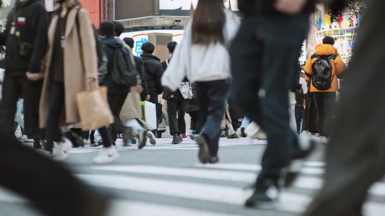 一群日本人、亚洲人、游客在东京涩谷的十字路口行走。日本旅游景点，旅游地标，亚洲交通城市生活理念视频素材