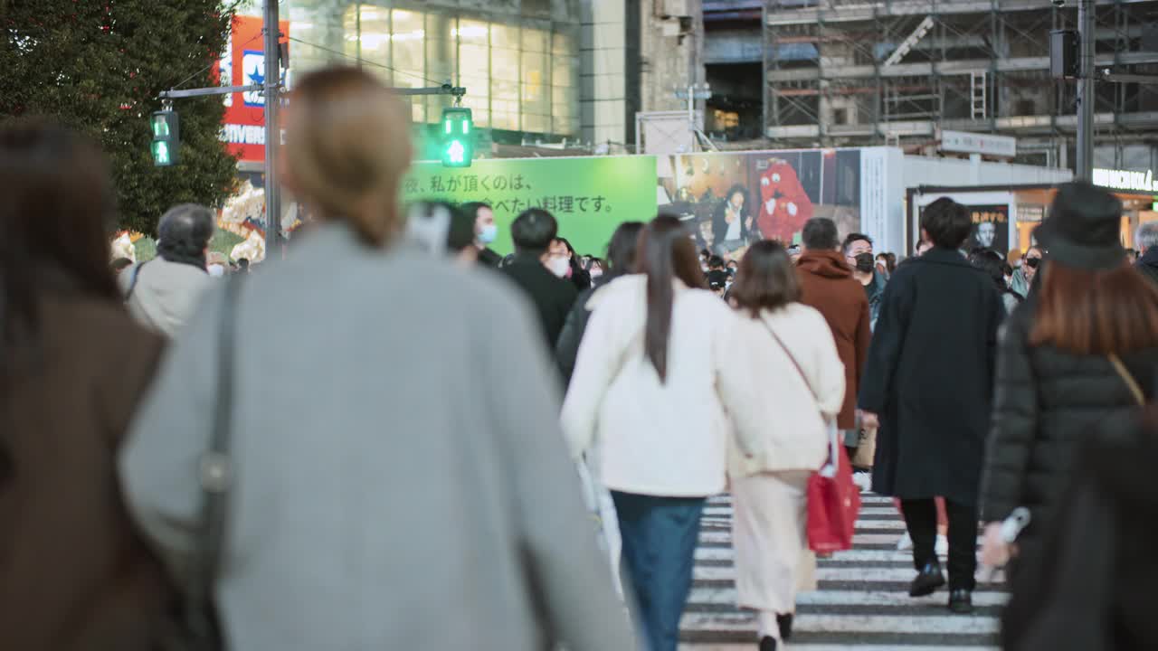 一群日本人、亚洲人、游客在东京涩谷的十字路口行走。日本旅游景点，旅游地标，亚洲交通城市生活理念视频素材