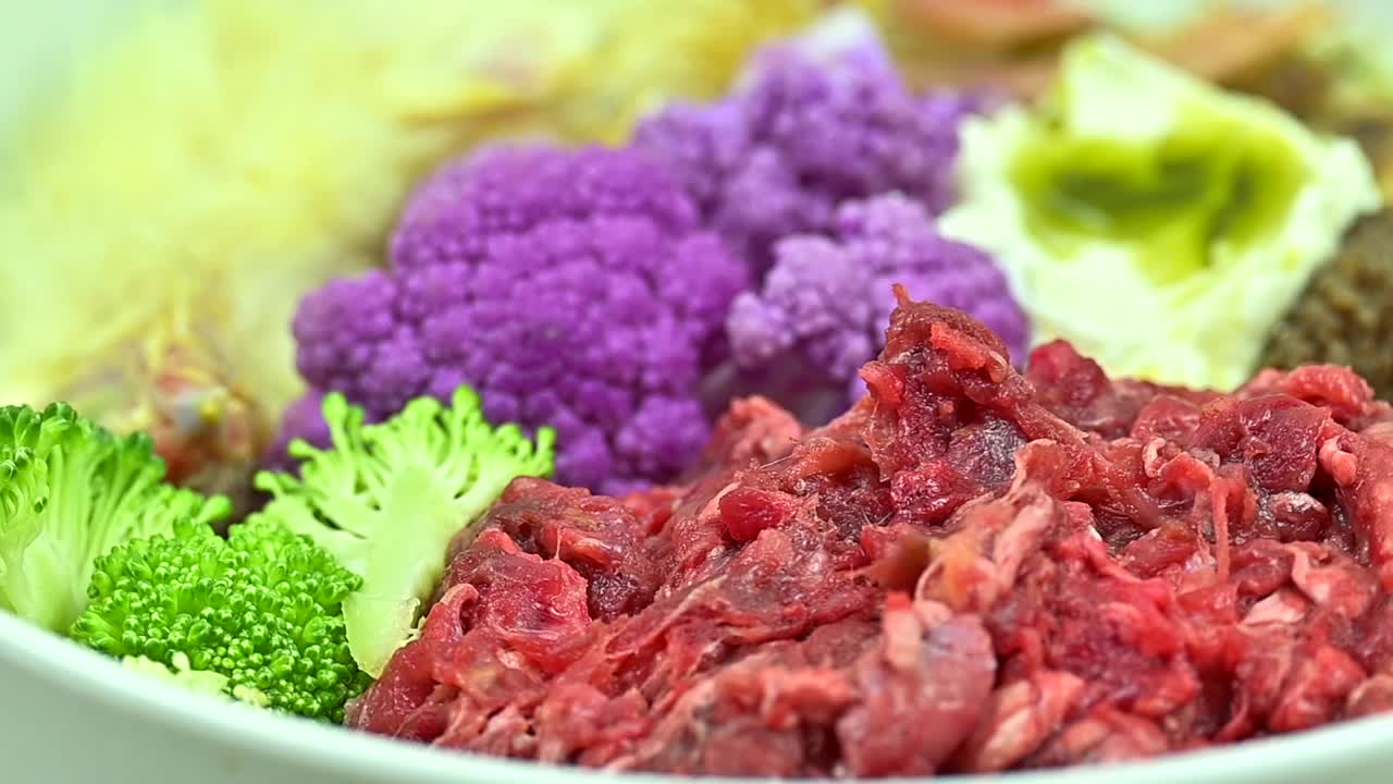 天然生狗粮。白碗里的鲜肉、鸡肉、牛肚、蔬菜、种子和油视频下载