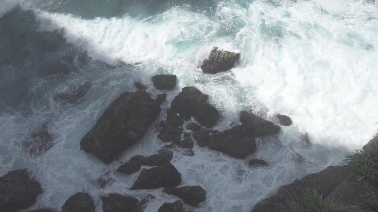 印度尼西亚巴厘岛努沙Penida -蓝色的水，巨大的海浪，强烈的潮汐击中岩石，危险而美丽的海洋在慢动作视频素材