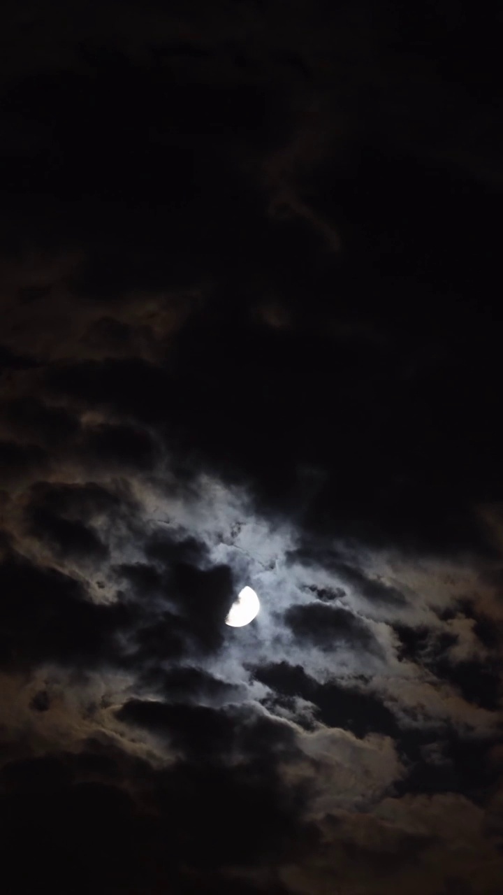 半月在漆黑的夜空中移动的时间特写。社交媒体的垂直视频。视频素材