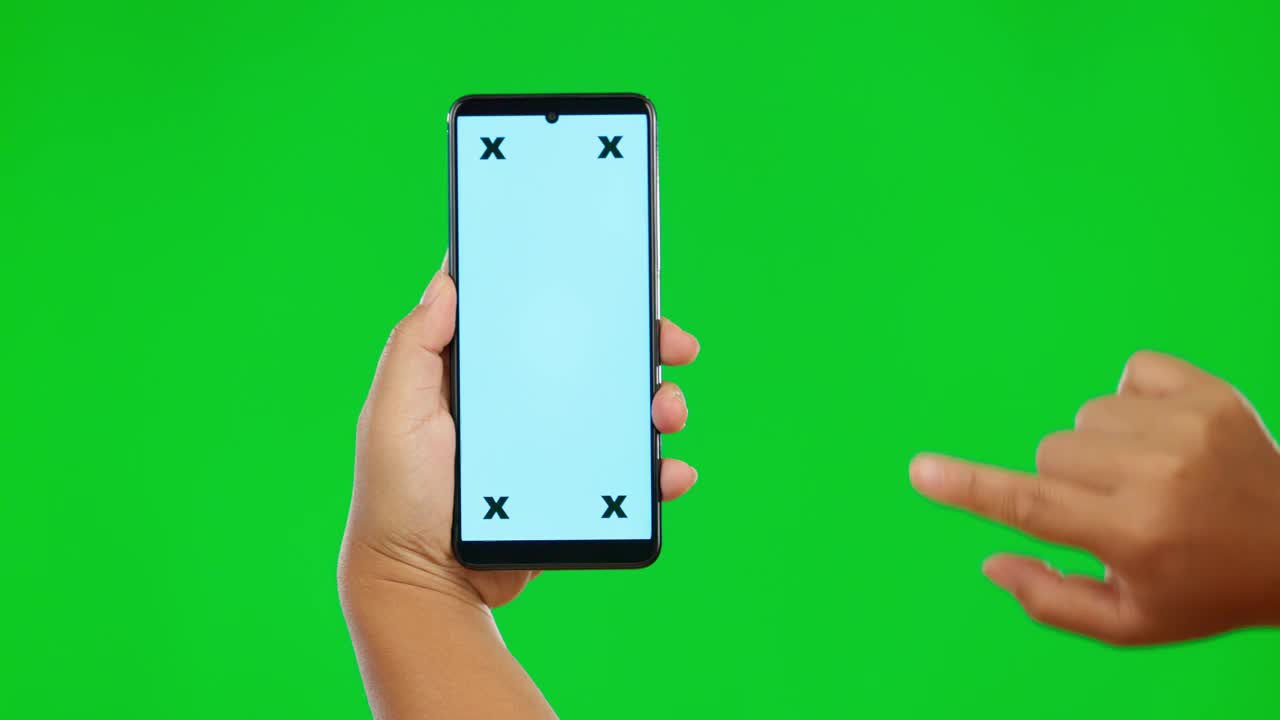 手、手机和绿色屏幕上的模型，以工作室为背景，用于社交媒体广告。手持移动智能手机应用程序的人，模拟显示和跟踪广告标记视频素材