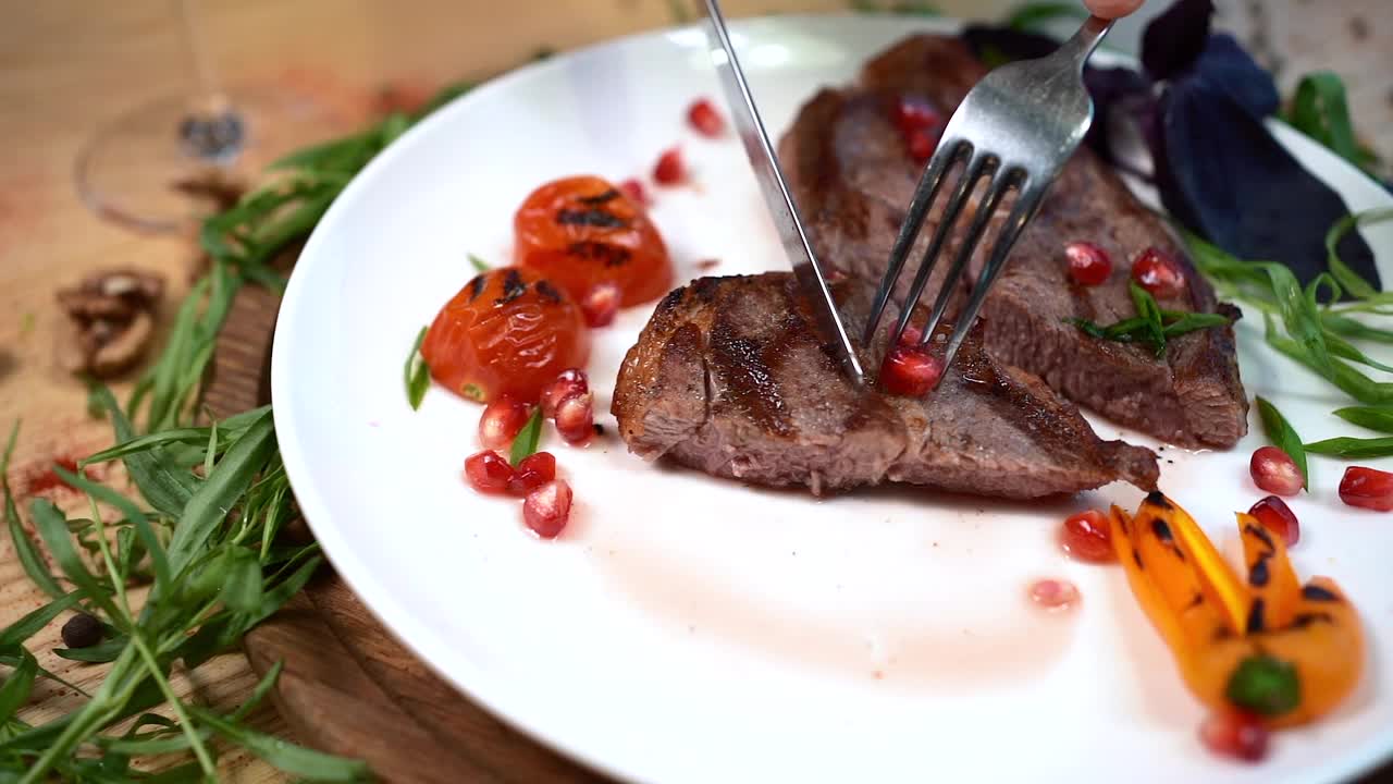 餐馆里的白盘子里，用香料或香草烤的手切牛排视频素材