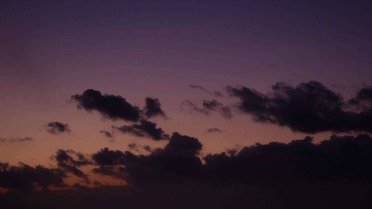 风景如画的乌云漂浮在淡紫色的黄昏天空中，彩色的天空作为背景，延时视频。视频素材