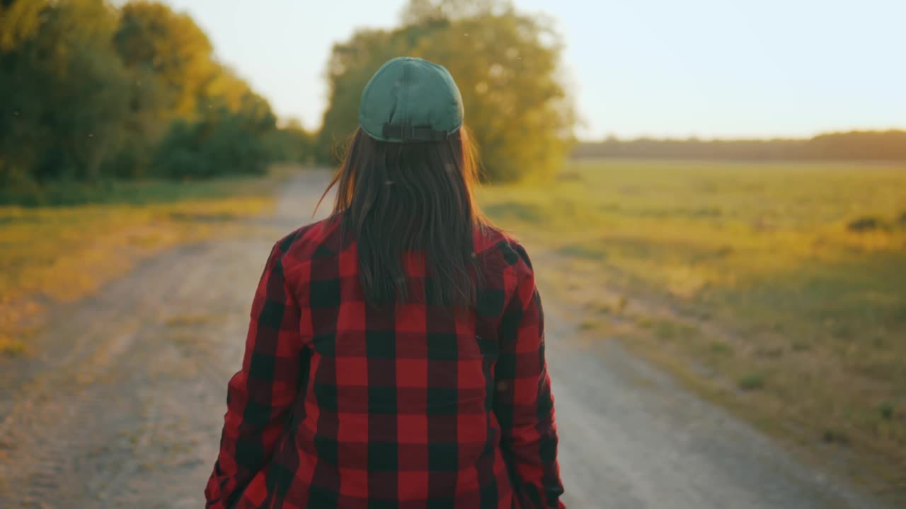 一名农业女工走在田野的土路上(后视图)视频素材