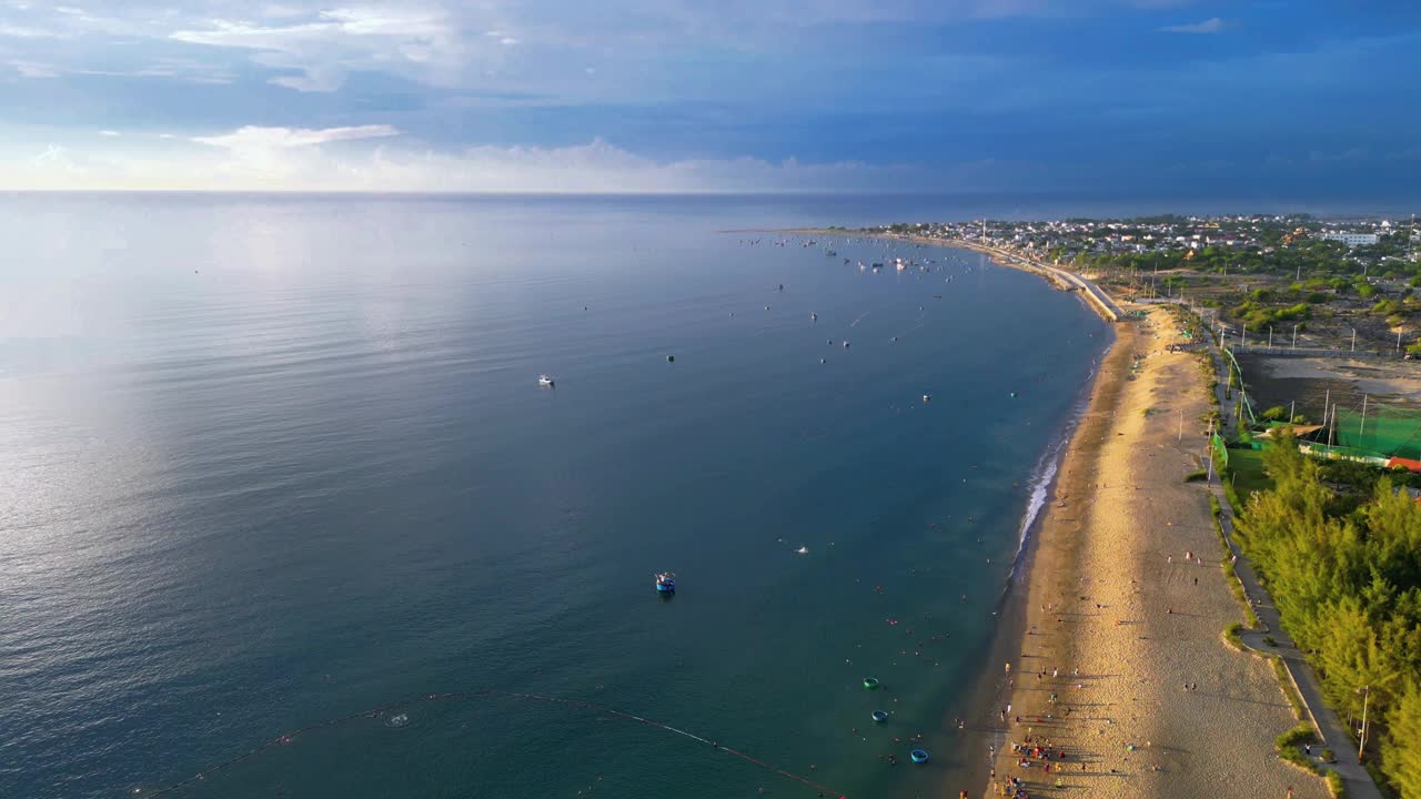 在一个晴朗的日子里，无人机在海滩上空飞行，蓝天，从高角度鸟瞰海浪和海水撞击沙滩的画面视频下载