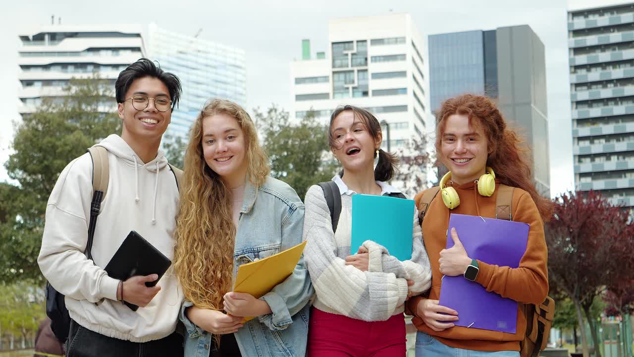 一群微笑的多民族青少年学生拿着文件夹看着相机视频素材