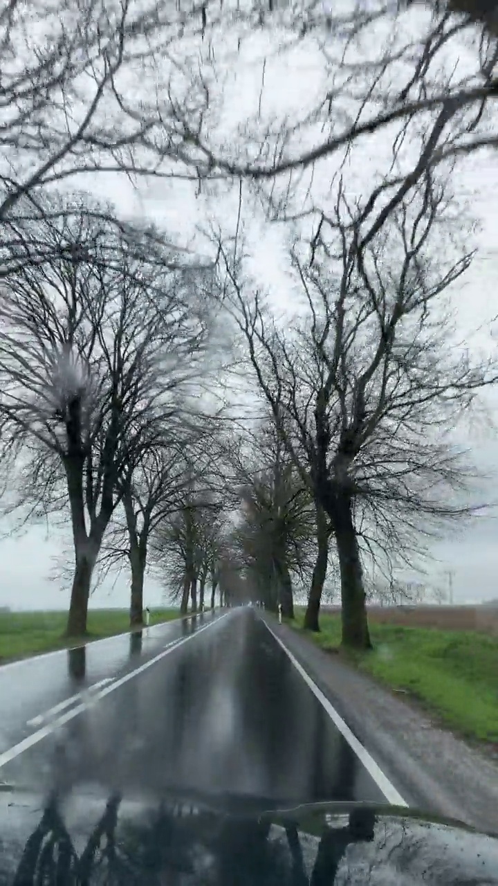 在雨中驾驶汽车在空旷的道路上——乘客的视角视频素材