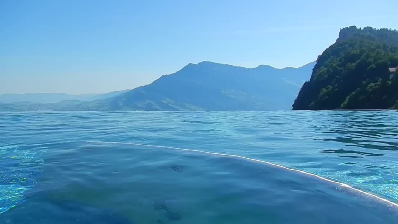 在一个阳光明媚的夏日，拥有山峰景色的无限游泳池视频素材