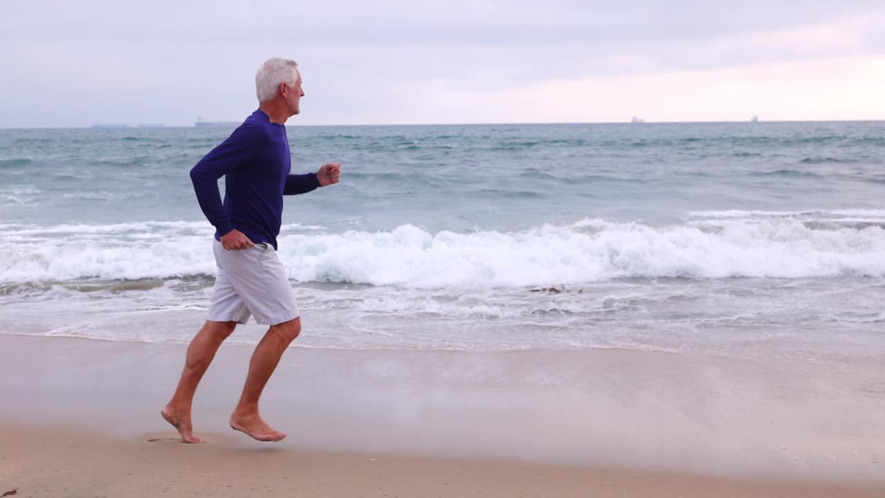 成熟的男人在海滩上锻炼视频素材