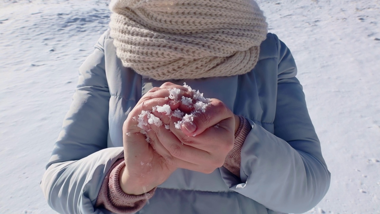 在寒冷的冬天下雪天，妇女们用手做雪球玩耍视频素材