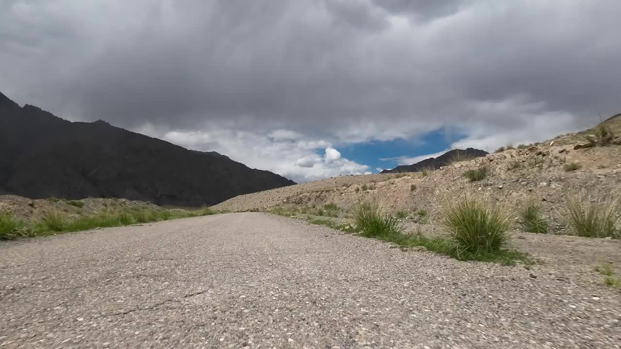 在壮观的天空下驾车行驶在山谷中。汽车的观点视频素材