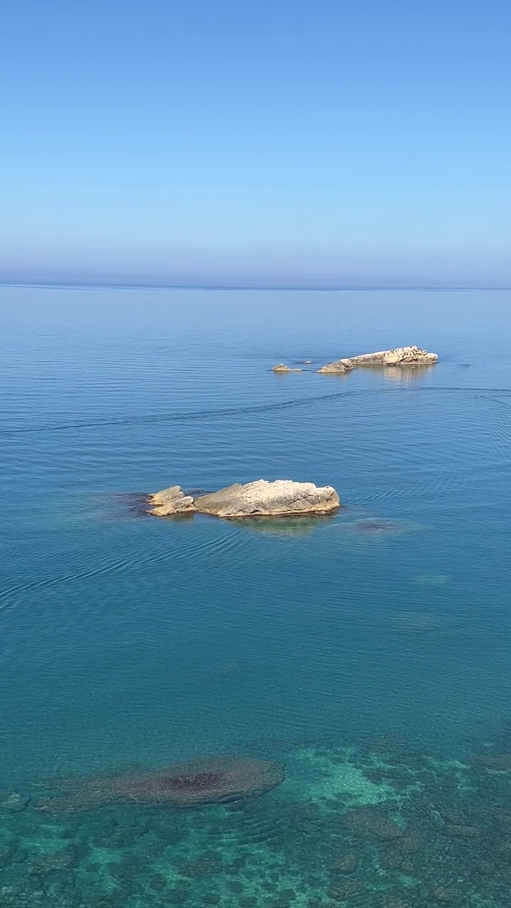 蓝色的大海和岩石在夏天，垂直视频。视频素材