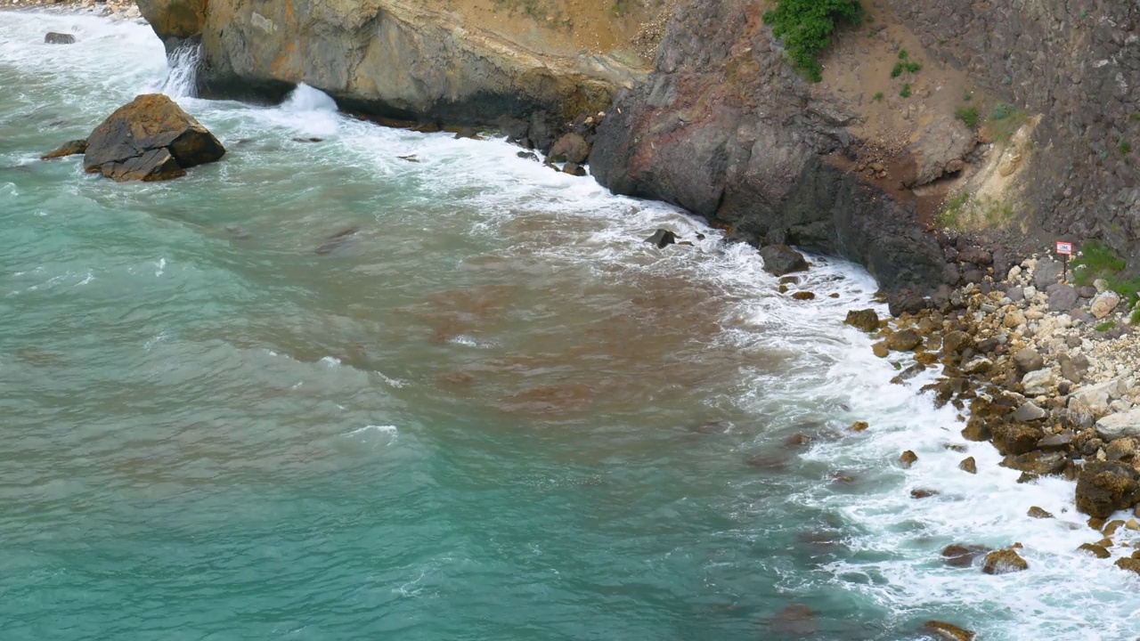 从上面看，海浪撞击着岩石。视频素材