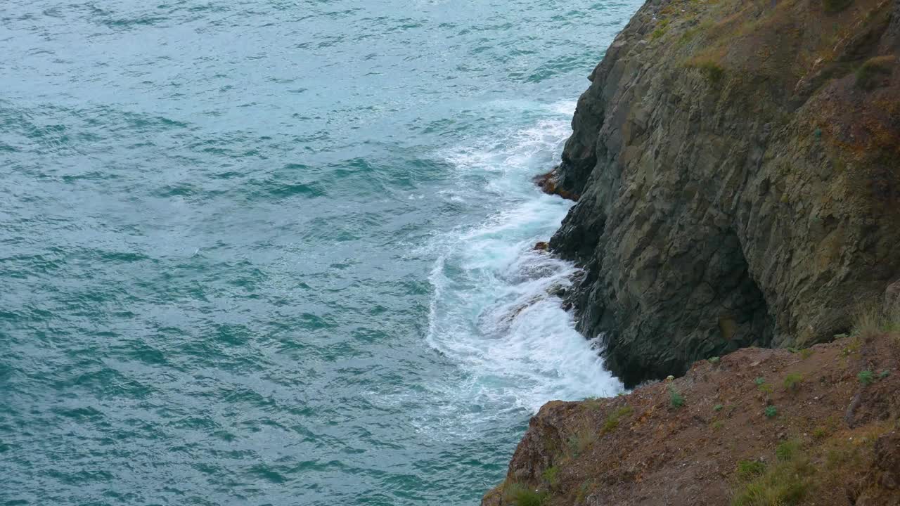 从上面看，海浪撞击着一块大石头视频素材