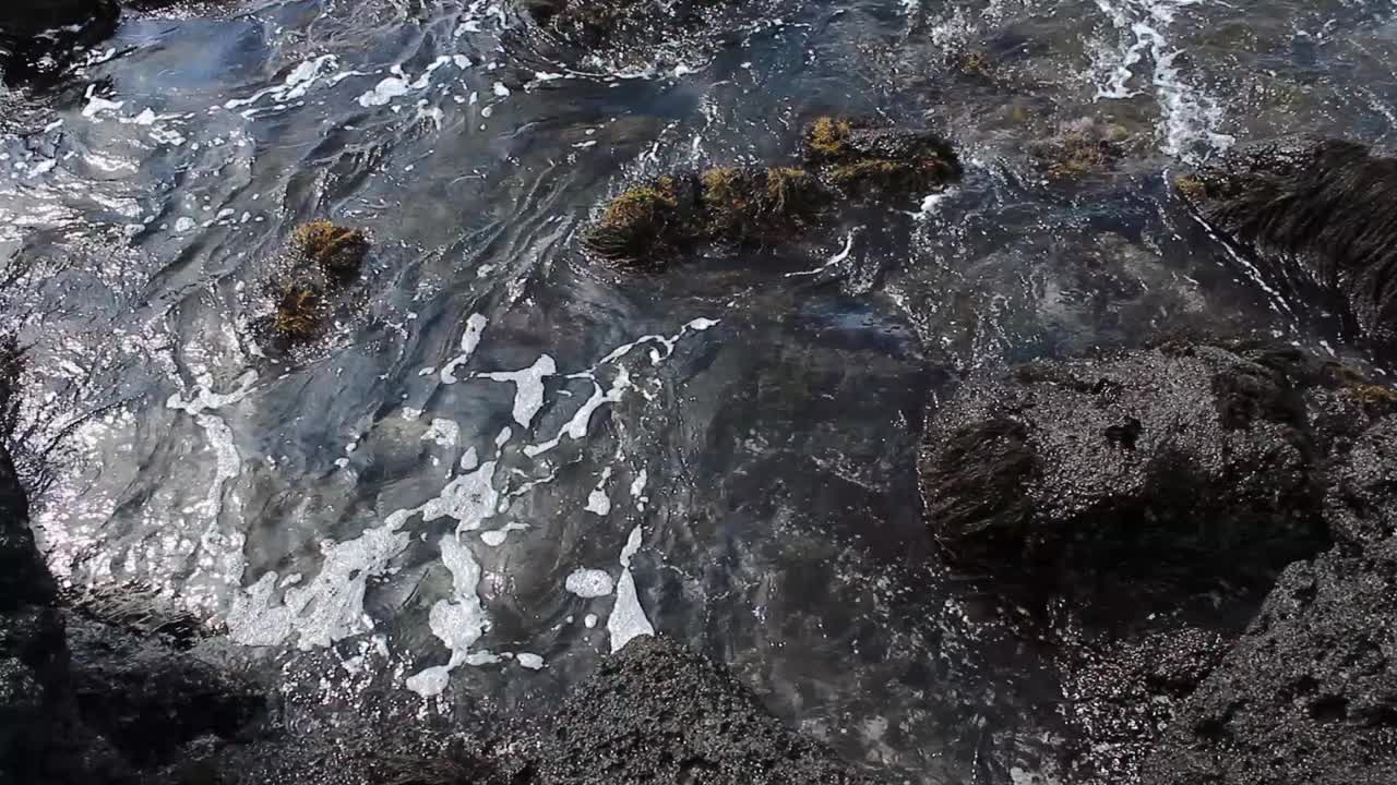 海浪在黑色玄武岩上打白的视频视频素材