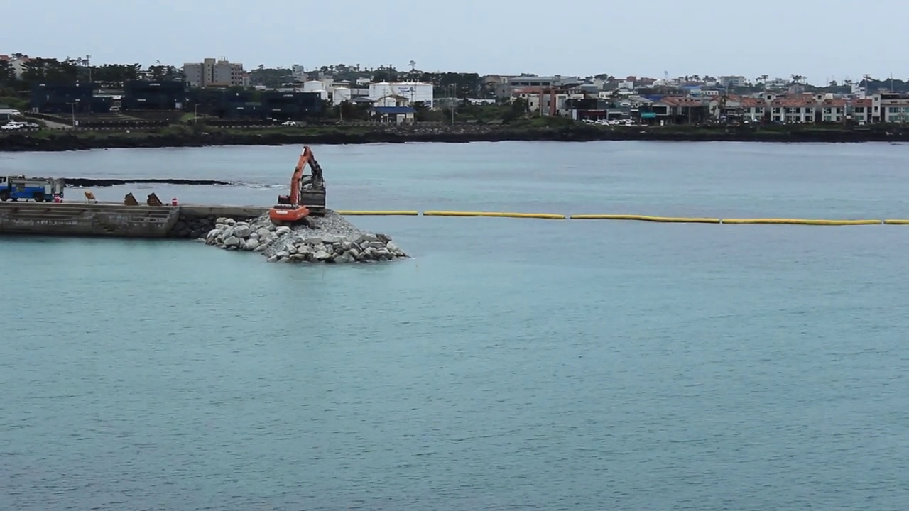 在济州岛爱月海岸，挖掘机正在扩建防波堤视频下载