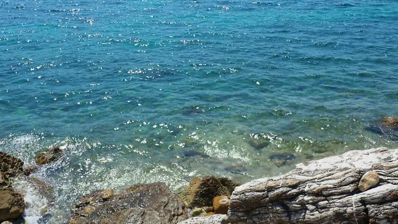 透明的海盐水质感。水面和涟漪的俯视图。海水海浪背景。长满海藻的岩石底部。浪花拍打着岩石。黑山，Herceg Novi视频素材