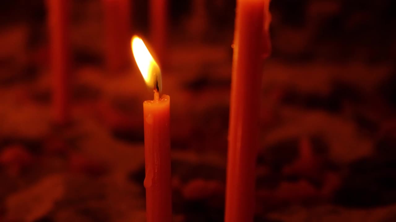 在黑暗中燃烧着红色烛台上的蜡烛，慢动作视频素材