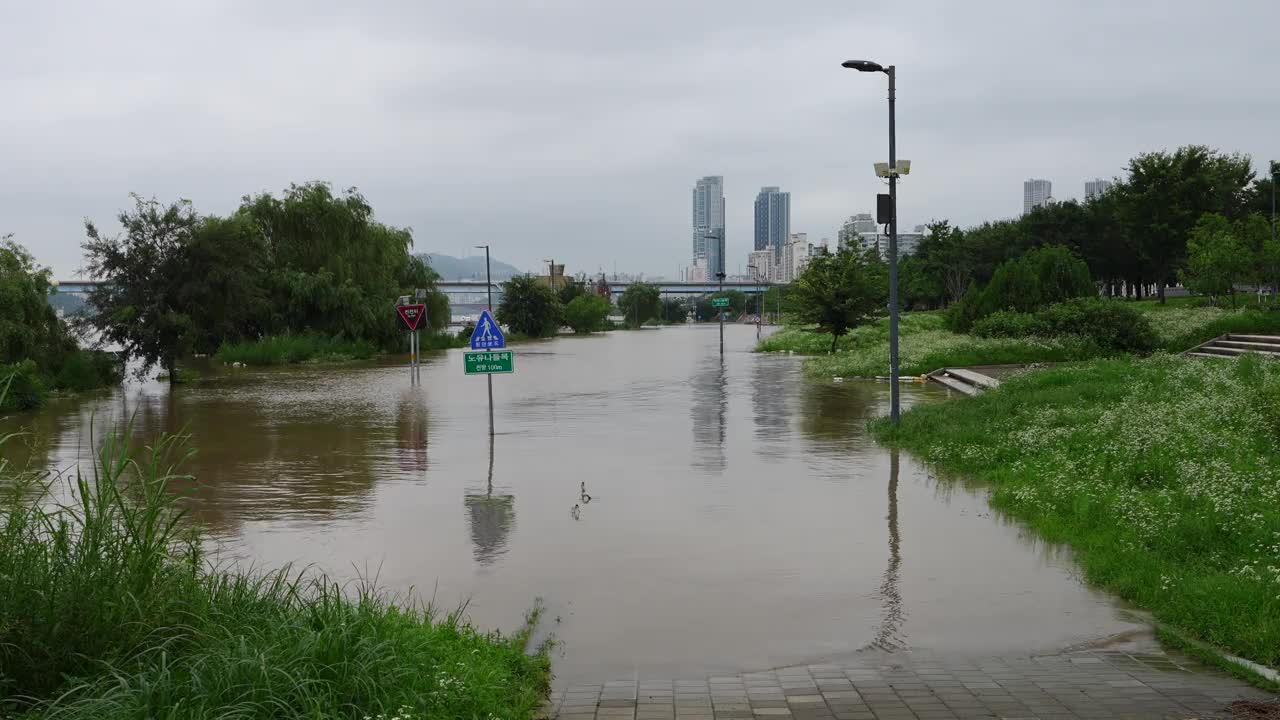 沿河的自行车道被洪水淹没，所以水面上只能看到道路标志。视频下载