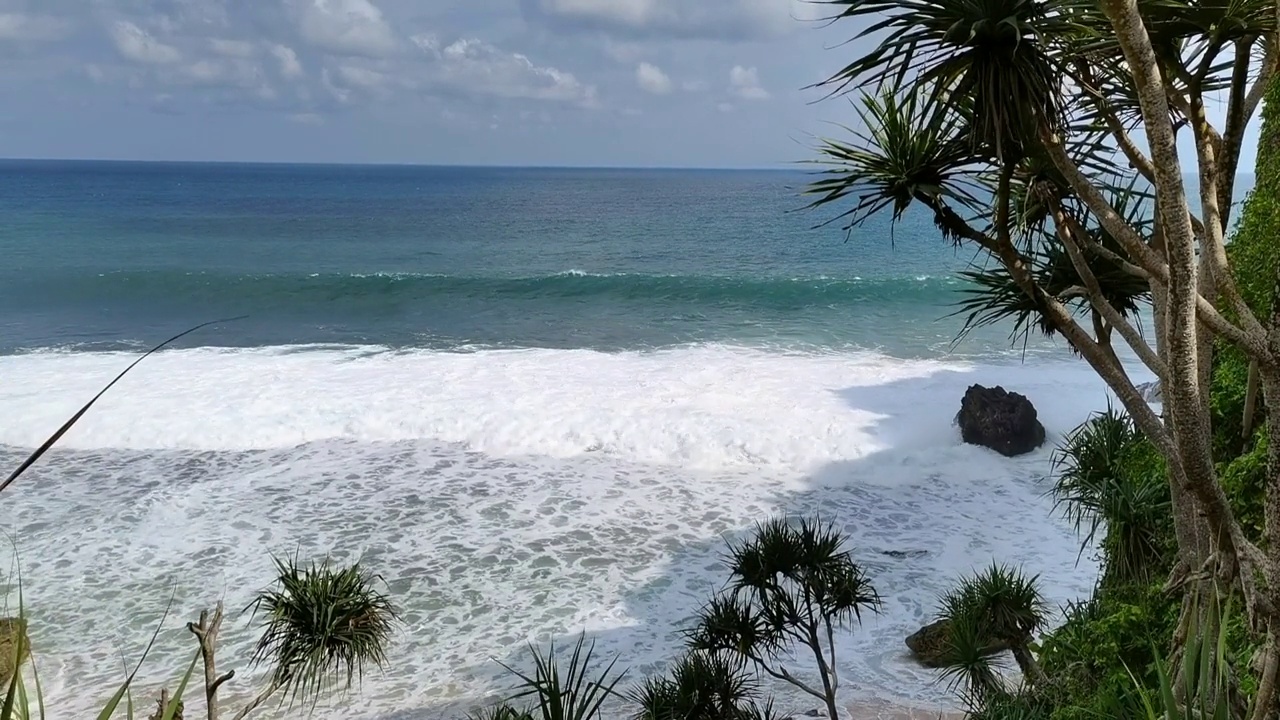 美丽的风景，蓝天和海浪在karang payung海滩，沃诺里，中爪哇，印度尼西亚视频下载