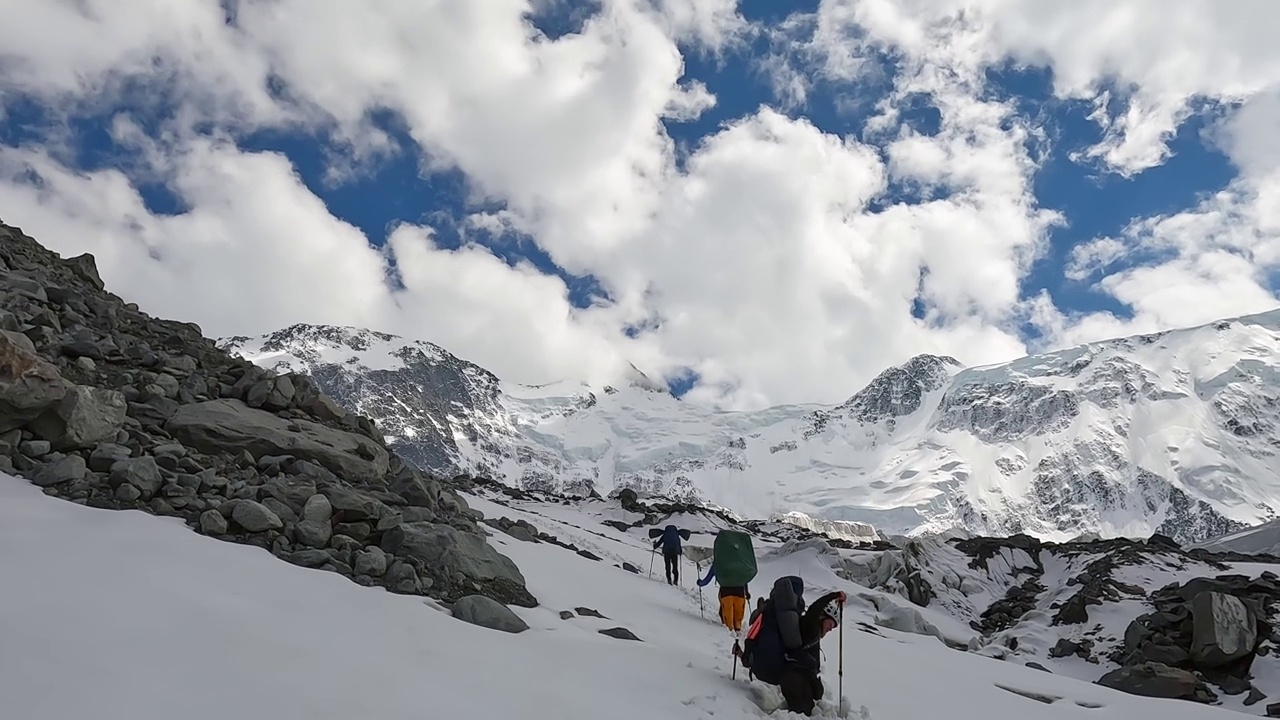 一个登山者在山间小路上行走时，掉进了厚厚的雪中。视频素材