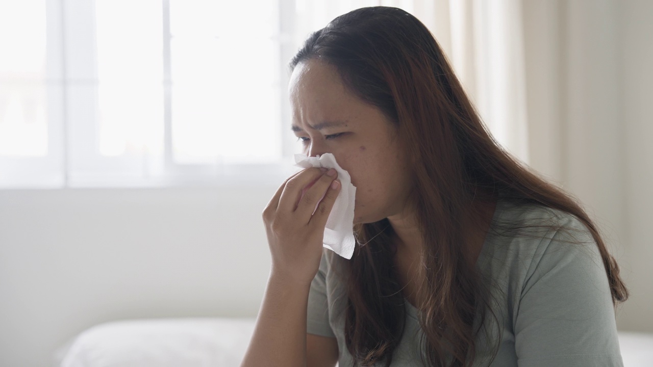 沮丧的生病的女人坐在床上视频素材