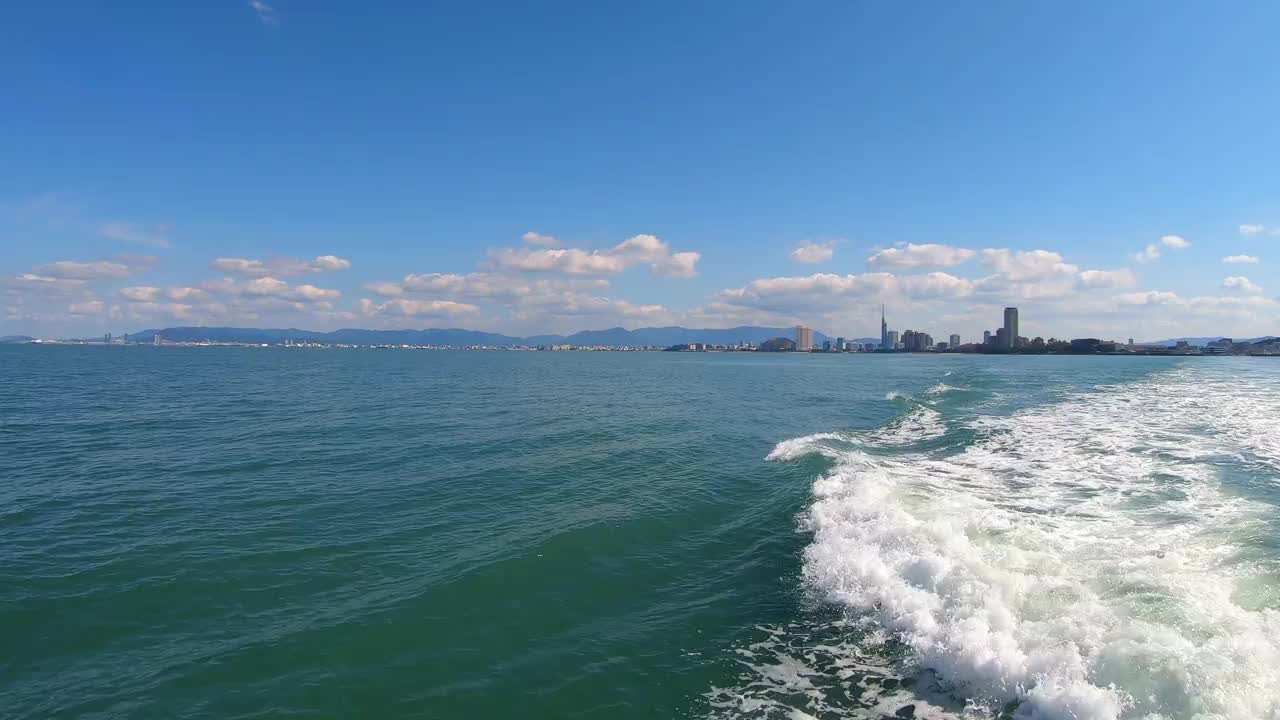 POV从船上拍摄海浪。飞溅的水和涟漪的泡沫。福冈市的夏季景观。视频下载