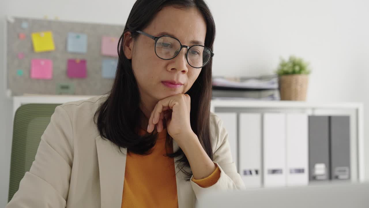 商务上，亚洲女性成功，亚洲女性在家用电脑办公时开心微笑视频素材