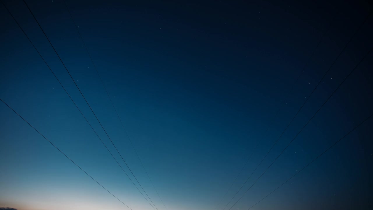 黎明即将来临。4k延时夜空星空。天空中神奇的星星效应。黎明的天空。柔和的蓝橙粉色。电力线上方的星星轨迹。夜空背景上的星迹。大曝光。恒星旋转的天空背景。时间流逝视频素材