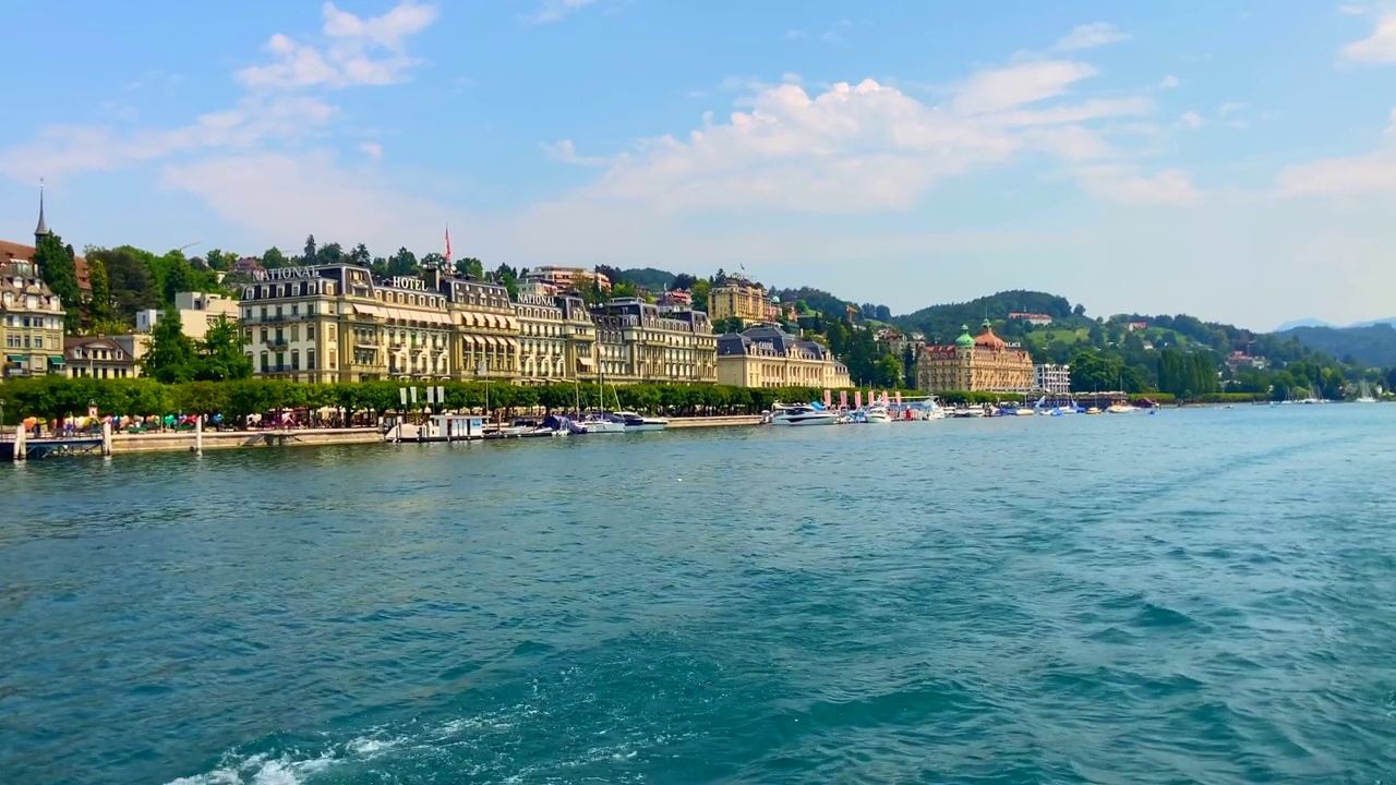 在一个阳光明媚的夏日，在卢塞恩市的卢塞恩湖上与山景一起旅行视频素材