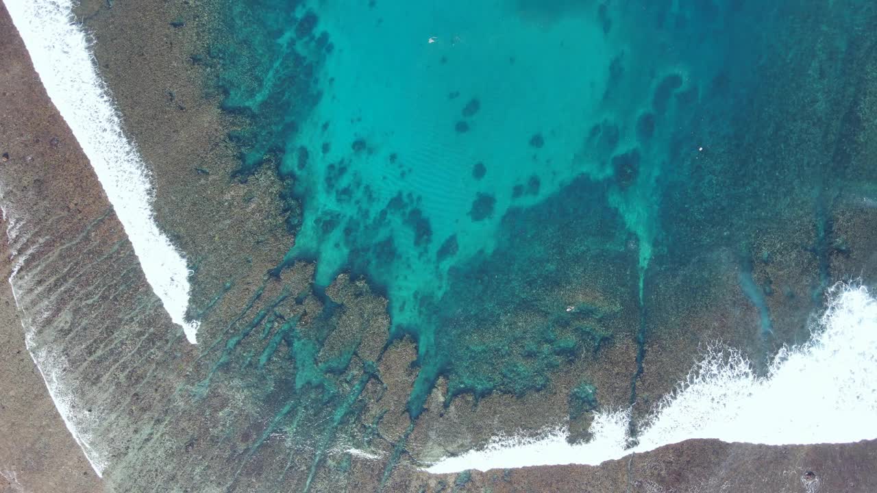 鸟瞰海浪到达努沙伦邦根岛的热带海滩景观，靠近巴厘岛，印度尼西亚视频素材