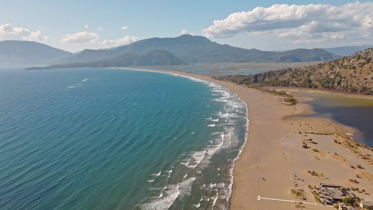 热带沙滩伊兹图祖海龟海滩和平静的蓝色大海，土耳其。自然无缝循环剪辑的热带空海滩与无限翻滚的海浪视频素材