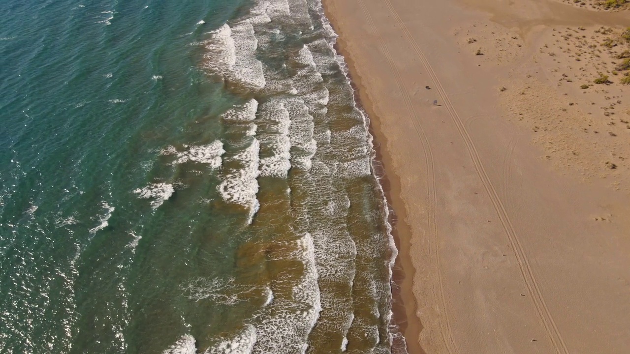 热带沙滩伊兹图祖海龟海滩和平静的蓝色大海，土耳其。自然无缝循环剪辑的热带空海滩与无限翻滚的海浪视频素材