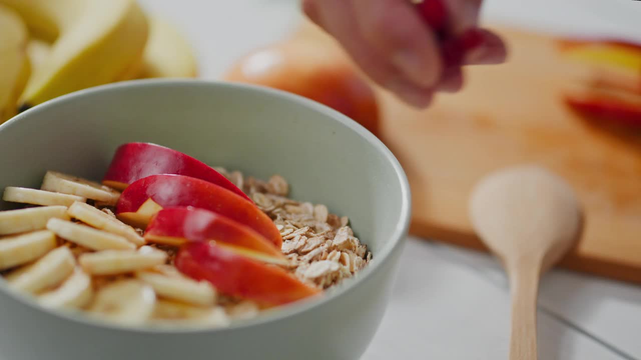 燕麦片，中年妇女用燕麦片做早餐，厨房里的燕麦片视频素材