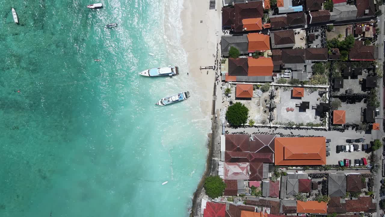 在Nusa Lembongan的Jungut Batu村，旅游快艇停泊在海滩上的码头的海岸线鸟瞰图。旅游目的地靠近巴厘岛，印度尼西亚视频素材