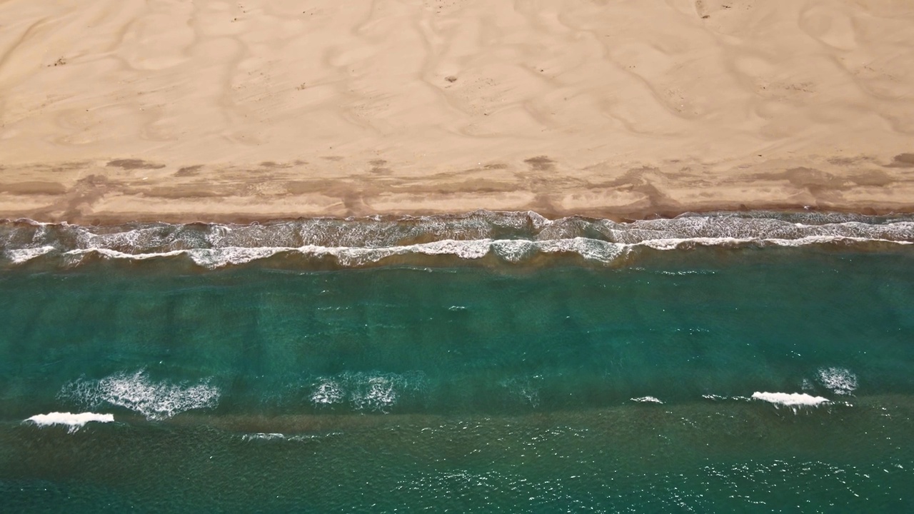 海浪或海浪。泡沫滚滚的海浪拍打着沙滩。空中俯瞰，4K。视频素材