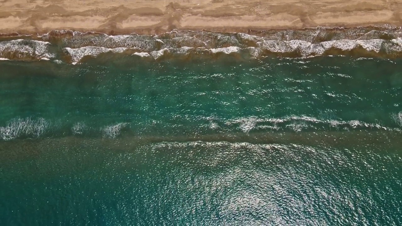 海浪或海浪。泡沫滚滚的海浪拍打着沙滩。空中俯瞰，4K。视频素材