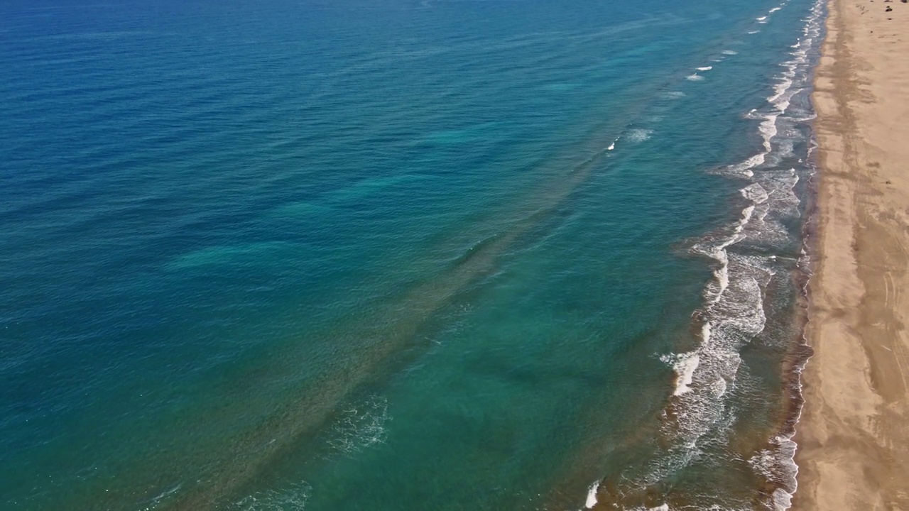 海浪或海浪。泡沫滚滚的海浪拍打着沙滩。空中俯瞰，4K。视频素材