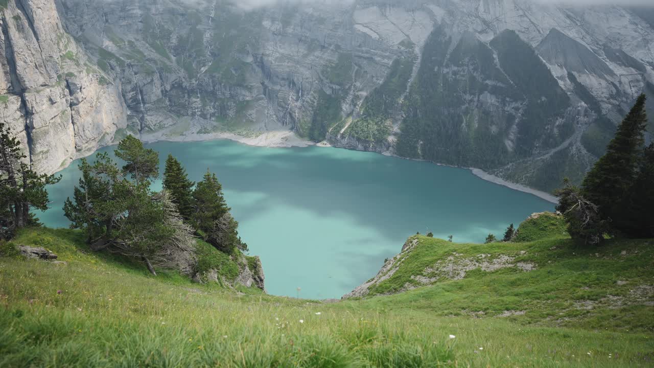 奥斯奇宁湖的空中无人机视图，上面有悬崖和雪峰的高山湖泊视频素材