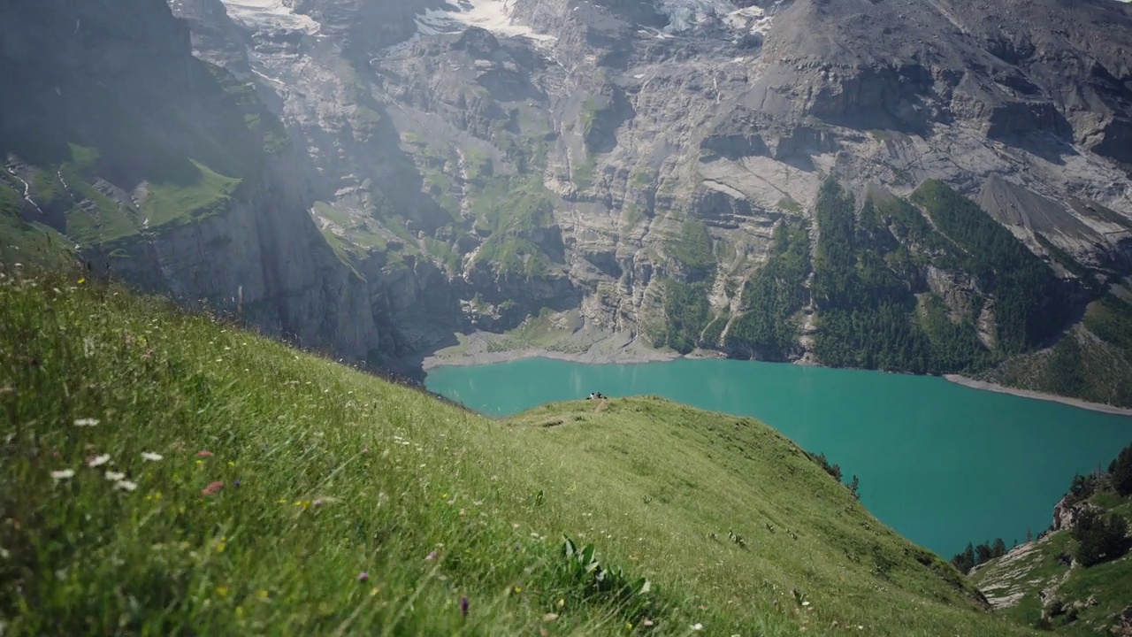 奥斯奇宁湖(Oeschinen Lake)高山湖泊，上面有悬崖和雪峰视频素材