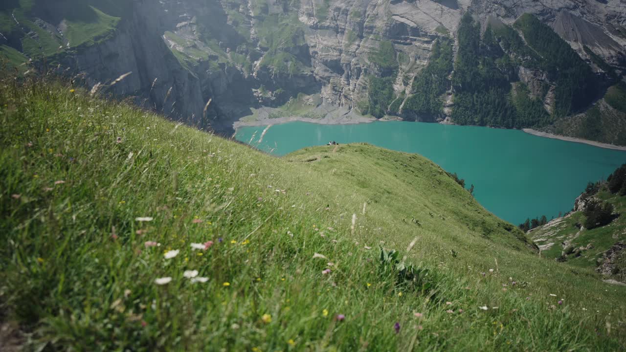 奥斯奇宁湖(Oeschinen Lake)高山湖泊，上面有悬崖和雪峰视频素材