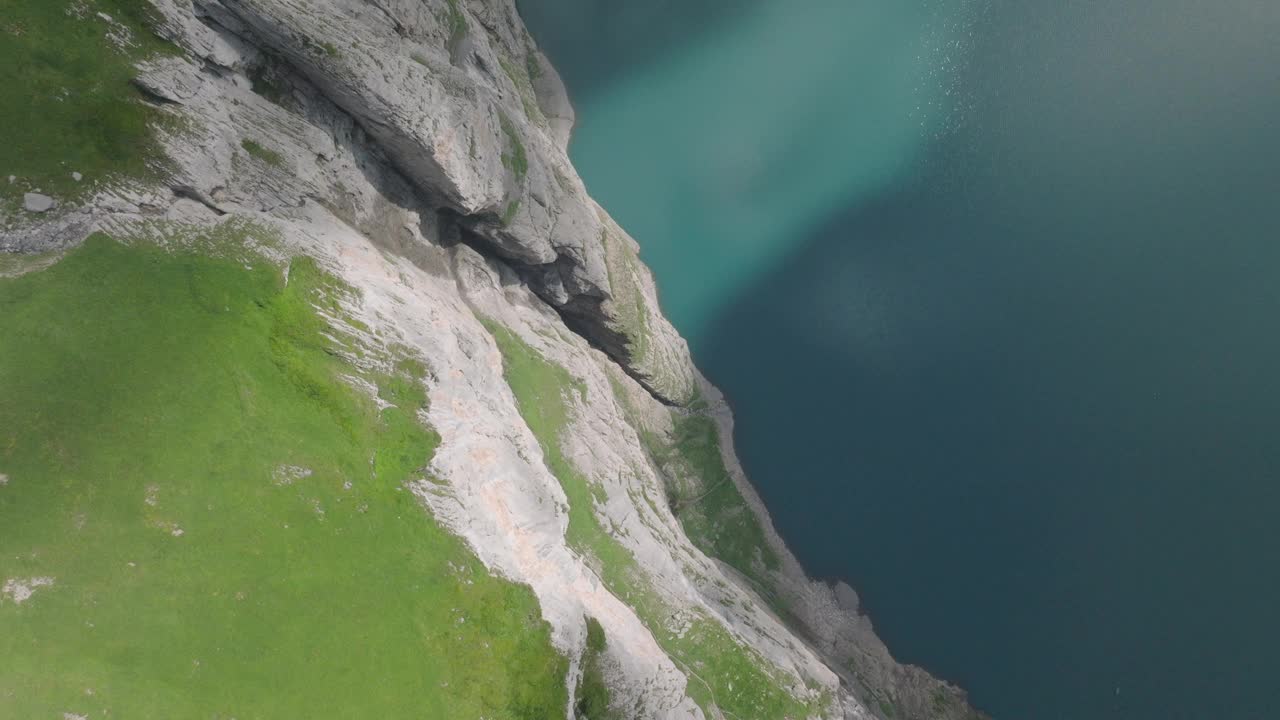 奥斯钦宁高山湖的景色，上面有悬崖和雪峰视频素材