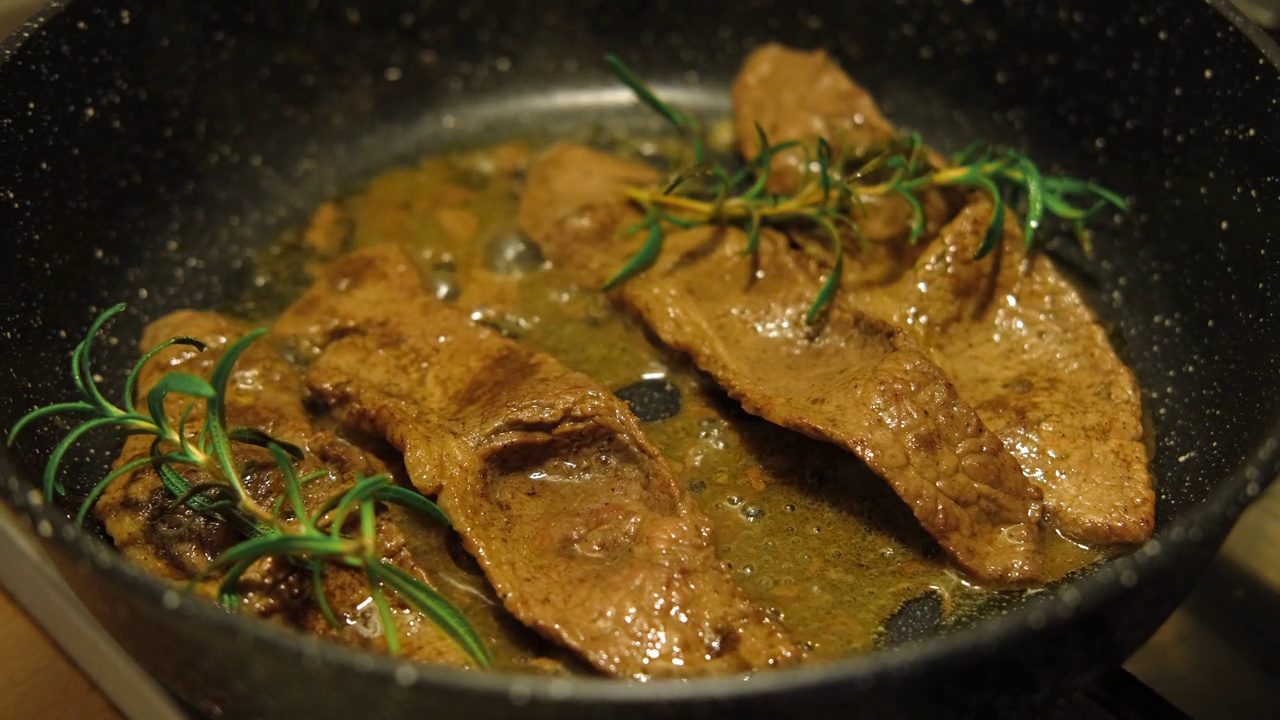 用香草黄油、胡椒和迷迭香煎牛肉片。煎肉排。特写镜头。煎牛眼肋排。菲力牛排。制作原味安格斯肋眼。食物配方背景视频素材