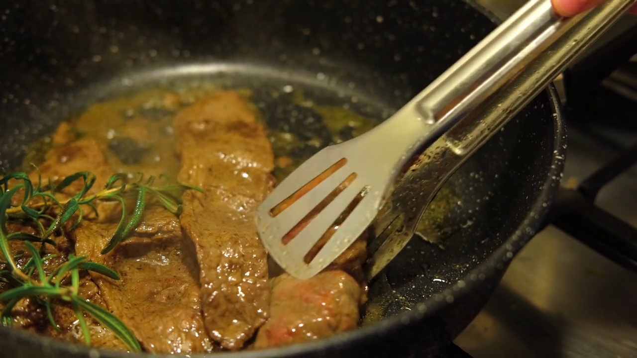 用香草黄油、胡椒和迷迭香煎牛肉片。煎肉排。特写镜头。煎牛眼肋排。菲力牛排。制作原味安格斯肋眼。食物配方背景视频素材