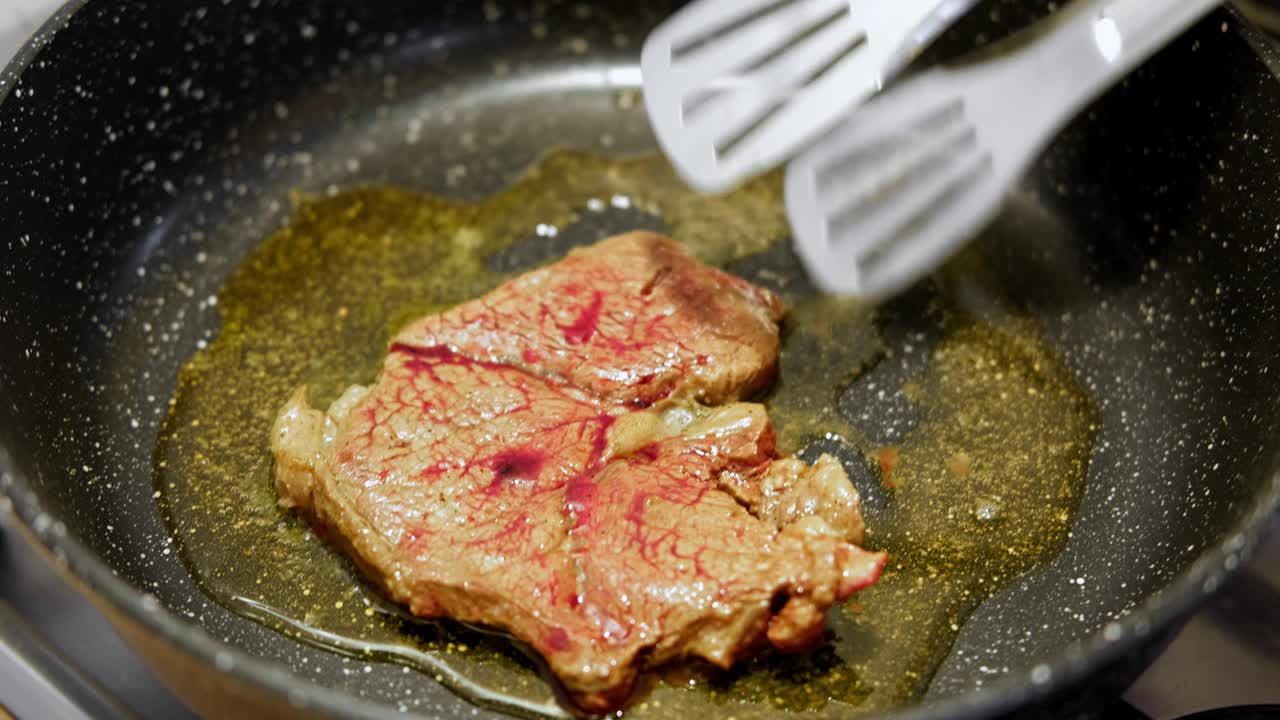 用香草黄油、胡椒和迷迭香煎牛肉片。煎肉排。特写镜头。煎牛眼肋排。菲力牛排。制作原味安格斯肋眼。食物配方背景视频素材